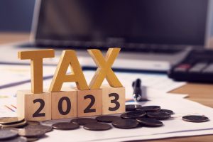 Taxer la lettre en bois et le numéro 2023 sur un bloc de bois. Payer l'impôt en 2023 ans.