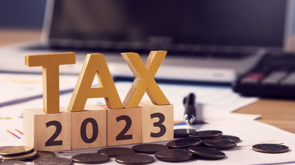 Taxer la lettre en bois et le numéro 2023 sur un bloc de bois. Payer l'impôt en 2023 ans.
