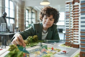 Jeune architecte travaillant sur une maquette de bâtiment, elle développe un nouveau projet de construction au bureau